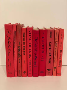 Red books with black titles by the foot for decor