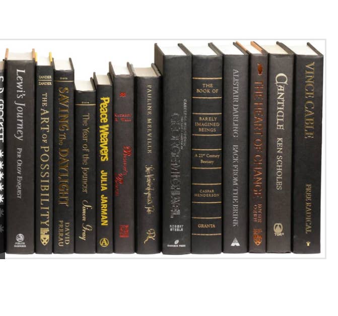 Black books with multi color titles by the foot for decor
